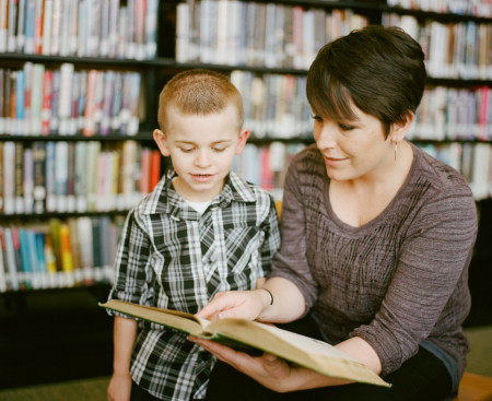 Teacher and pupil reading together 