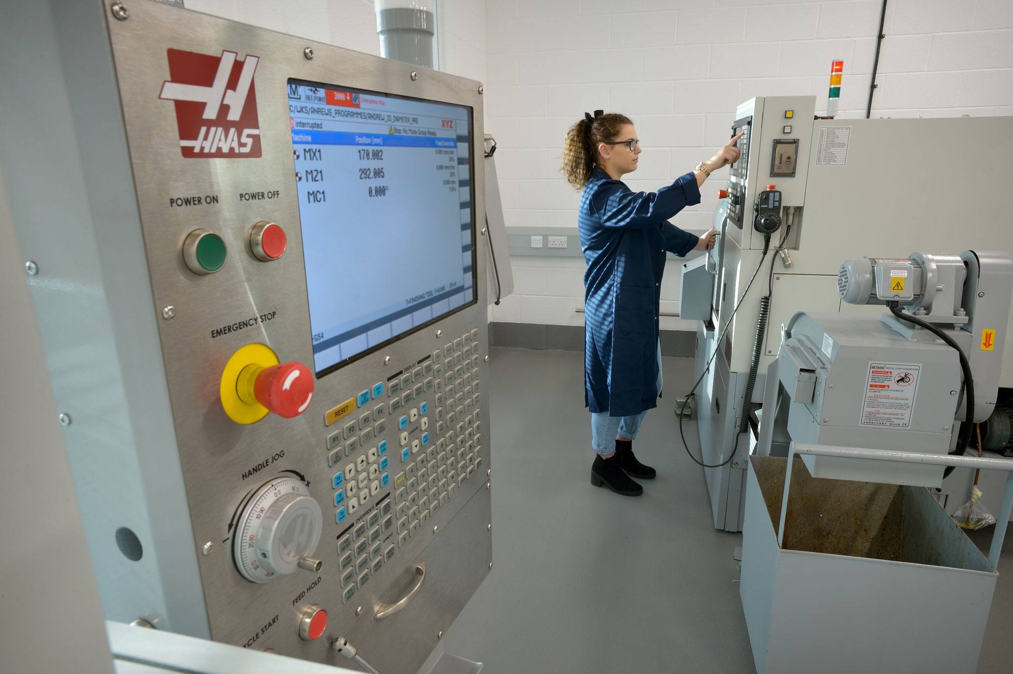 A student using a CNC machine in a mechanical engineering laboratory